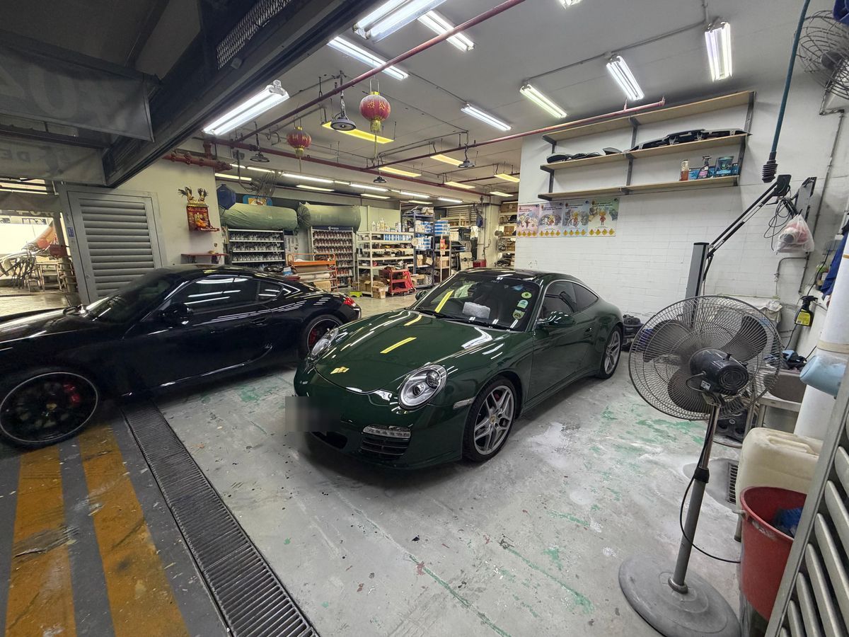 Two Porsches parked inside the workshop